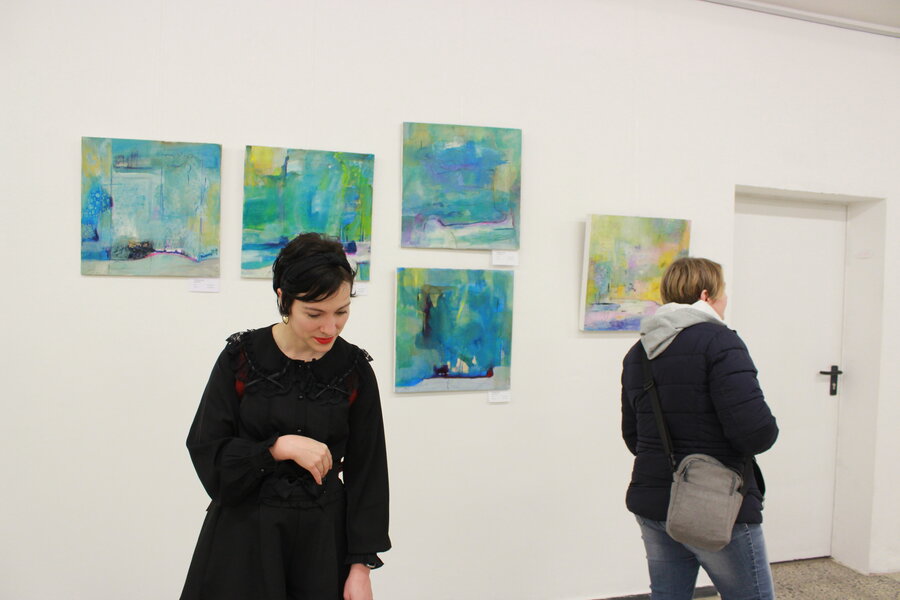 Besucher in der Ausstellung "Schön Subjektiv". Die Gemälde im Hintergrund sind von Christina Greil